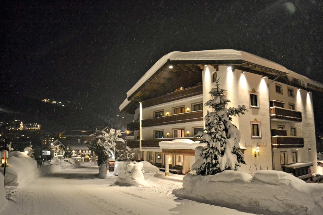 Winterliche Abendstimmung in Lech – das Hotel Theodul erstrahlt im warmen Licht und lädt nach einem Tag im Schnee zum Ankommen und Wohlfühlen ein.