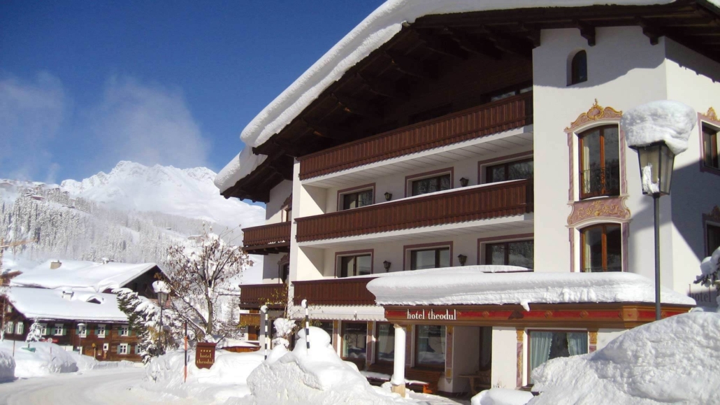 Winterliche Idylle in Lech – das Hotel Theodul umgeben von tief verschneiter Bergkulisse, ein Ort zum Ankommen, Wohlfühlen und Genießen.