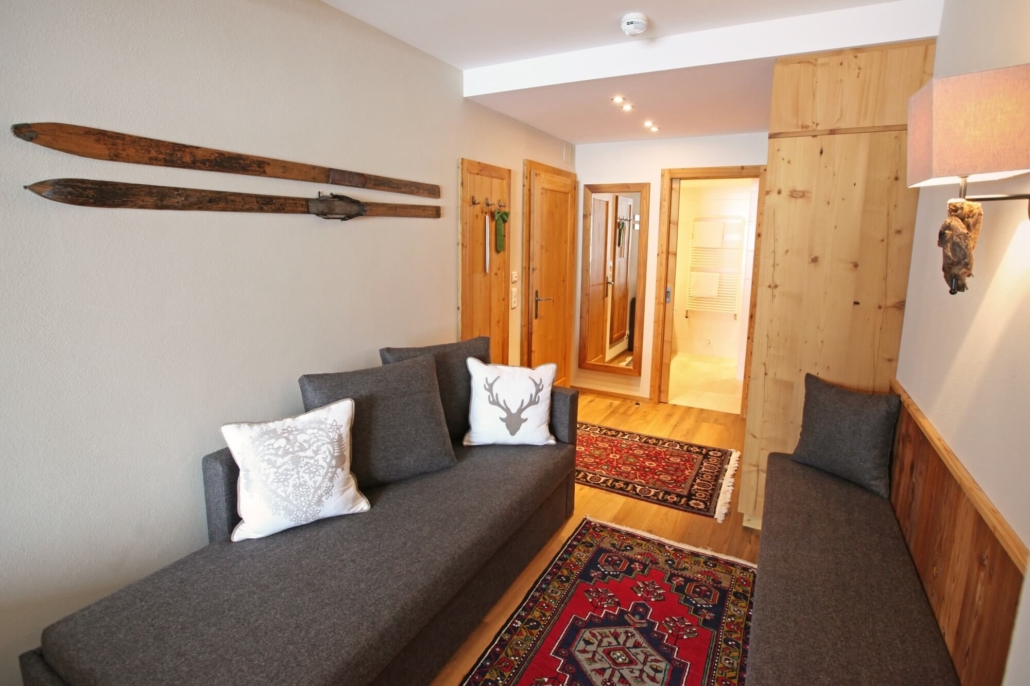 Wohnbereich im alpinen Stil mit traditionellen Teppichen, Holzelementen und rustikaler Wanddekoration
