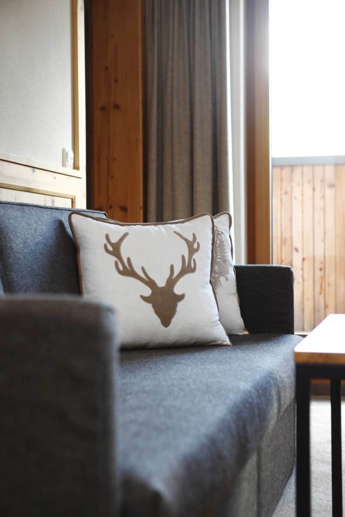 Gemütliche Sitzecke im alpinen Stil – natürliche Materialien und liebevolle Details sorgen im Hotel Theodul in Lech für Wohlfühlatmosphäre.